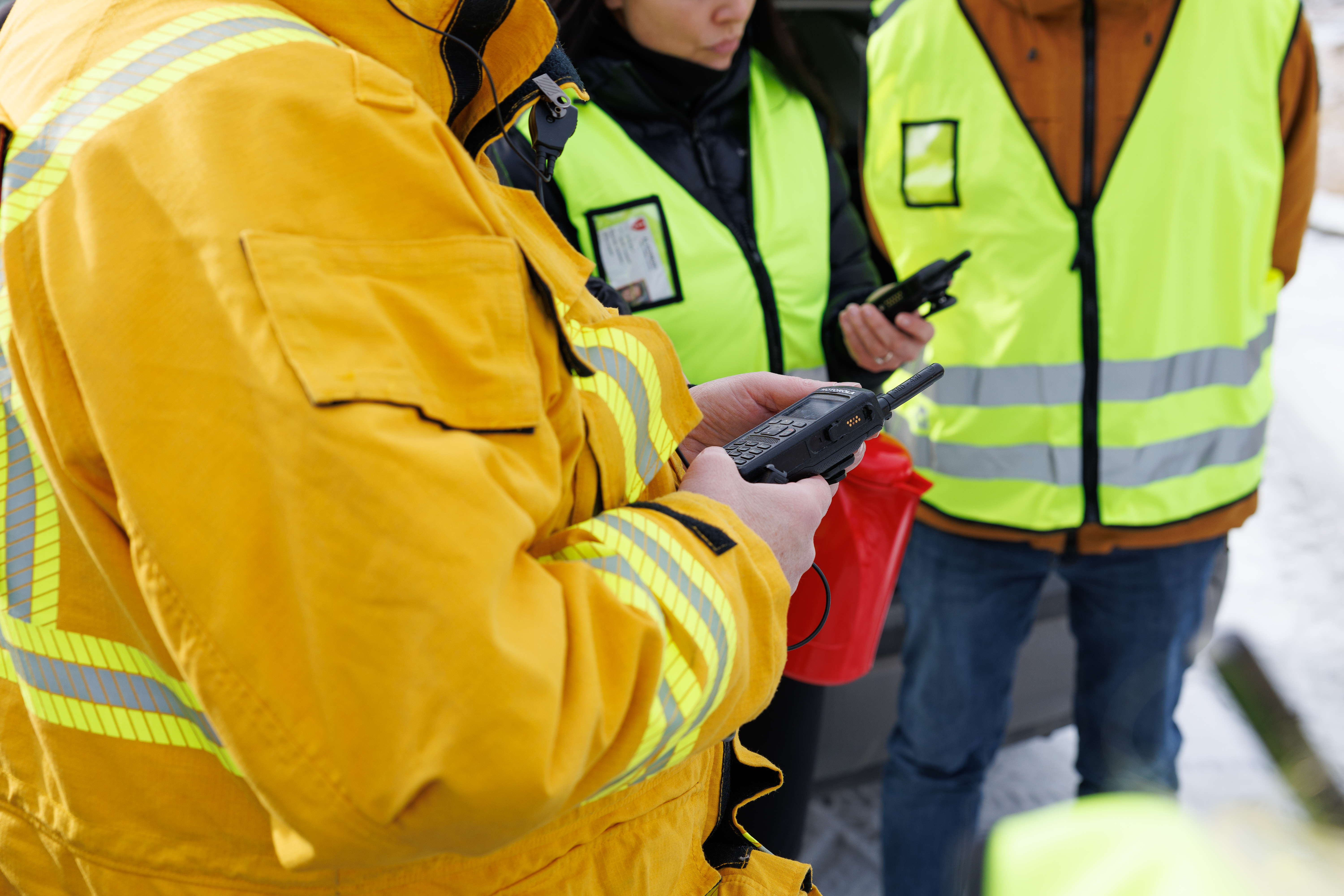 Bilde av personer i refleksvest med walkietalkie