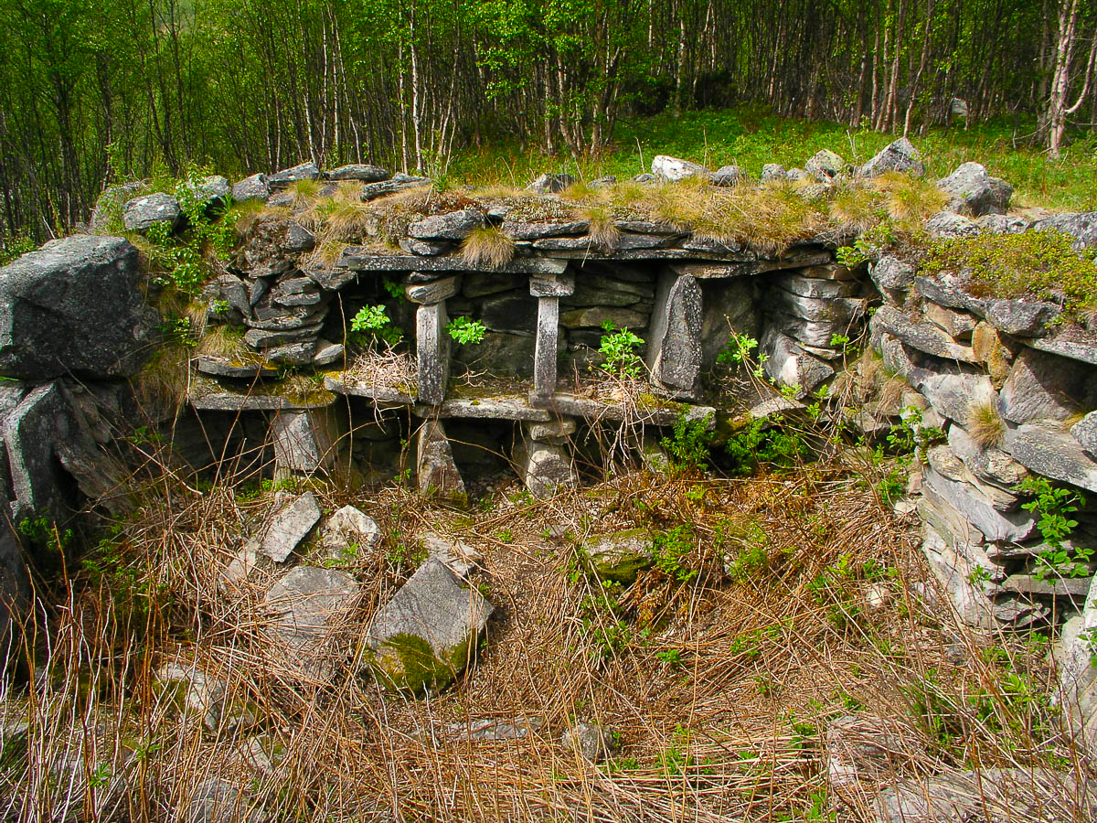 Bilde av gammel steinbygning der taket er borte i grønne omgivelser. 